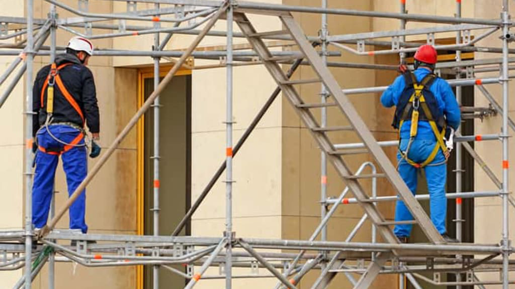 Certified scaffolders on harnessed facade access scaffolding