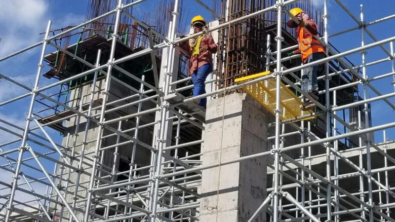 Scaffolding crews installing tube-and-fittings facade access on a UAE high-rise project
